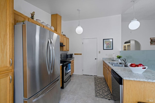 kitchen featuring a sink, appliances with stainless steel finishes, hanging light fixtures, and under cabinet range hood