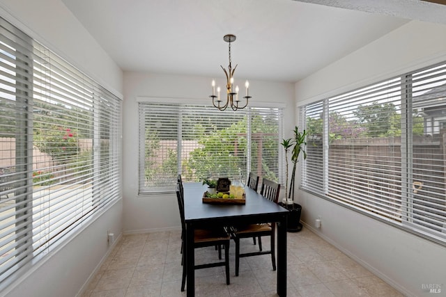 dining area featuring baseboards, an inviting chandelier, and light tile patterned floors