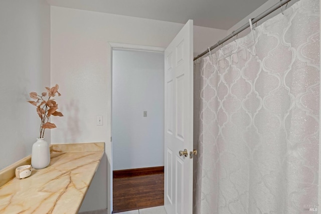 bathroom featuring baseboards and a shower with curtain