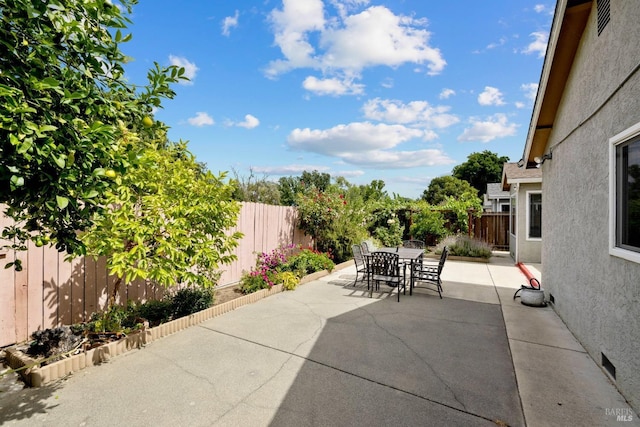 view of patio with outdoor dining area and a fenced backyard