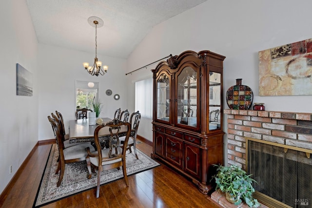 dining area featuring baseboards, a notable chandelier, dark wood-style floors, and lofted ceiling
