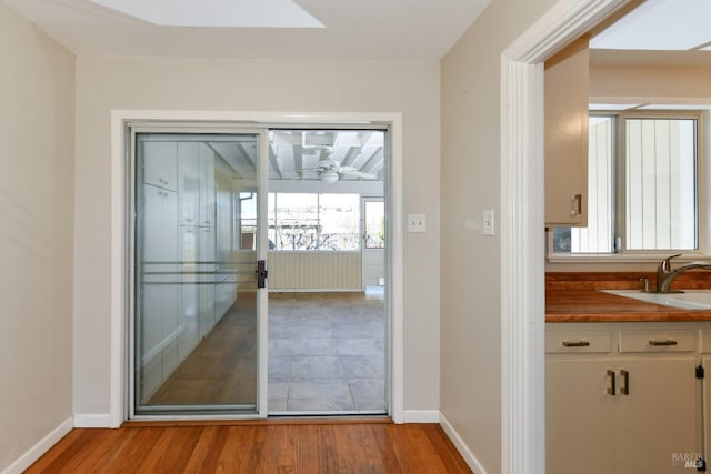 doorway with ceiling fan, light hardwood / wood-style floors, and sink