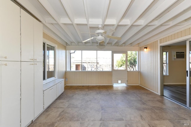 unfurnished sunroom featuring ceiling fan, beamed ceiling, and a wall mounted AC