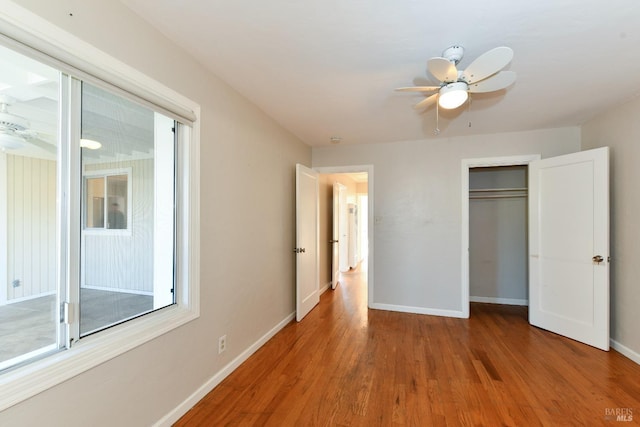 unfurnished bedroom with ceiling fan, a closet, and hardwood / wood-style flooring