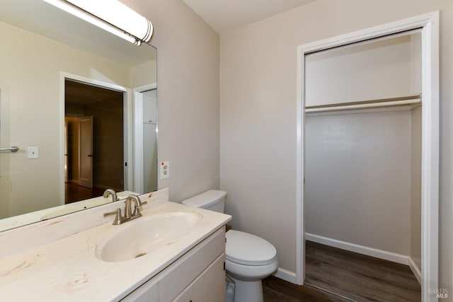 bathroom with toilet, hardwood / wood-style floors, and vanity