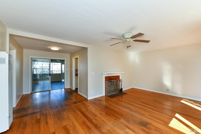 unfurnished living room with ceiling fan and dark hardwood / wood-style flooring