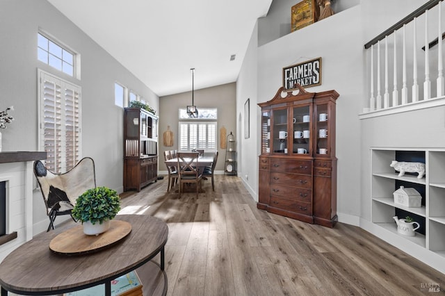 dining space featuring light hardwood / wood-style floors and high vaulted ceiling