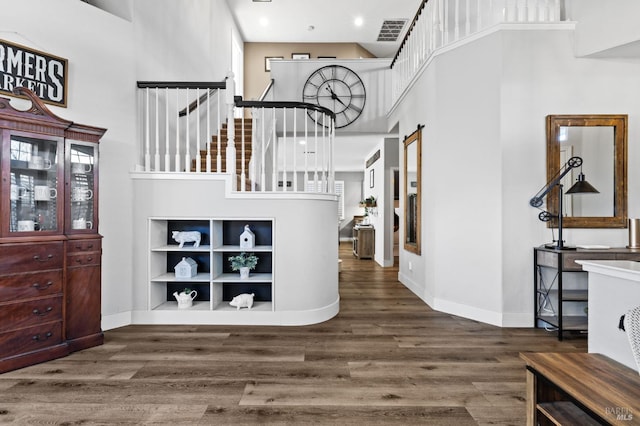 foyer featuring a healthy amount of sunlight, dark wood-type flooring, and a high ceiling