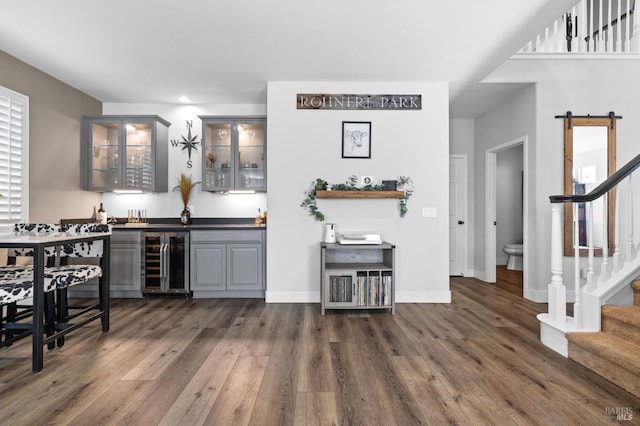 bar featuring gray cabinets, dark hardwood / wood-style flooring, and beverage cooler