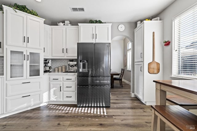 kitchen with backsplash, white cabinetry, dark hardwood / wood-style flooring, and refrigerator with ice dispenser