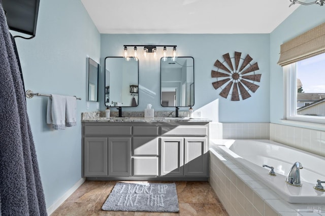 bathroom featuring tiled bath and vanity