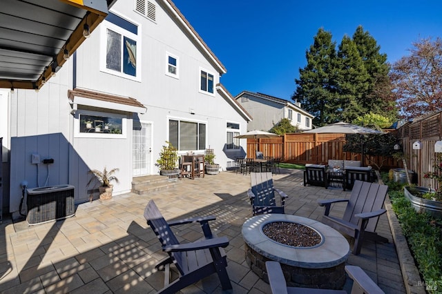 view of patio / terrace with central air condition unit and an outdoor living space with a fire pit