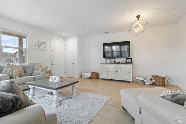 living room with recessed lighting, light wood-type flooring, baseboards, and visible vents