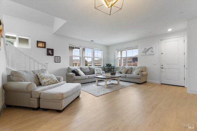 living area with stairway, recessed lighting, baseboards, and light wood-type flooring