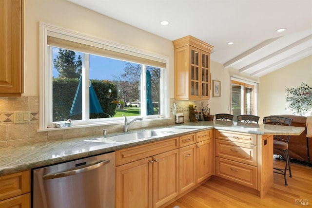 kitchen with kitchen peninsula, stainless steel dishwasher, light stone counters, lofted ceiling with beams, and light hardwood / wood-style floors