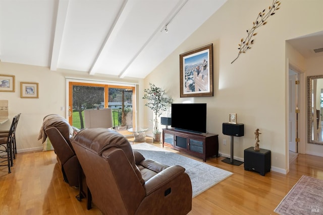 living room with light hardwood / wood-style flooring and lofted ceiling with beams