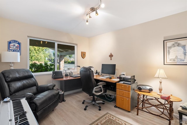 home office with light hardwood / wood-style flooring