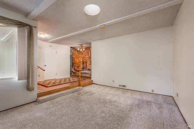 basement with ceiling fan, carpet, and a textured ceiling