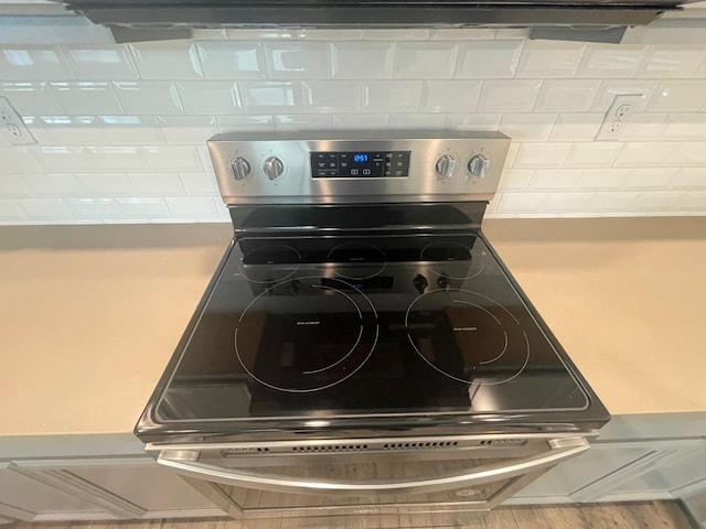 details with electric stove and backsplash