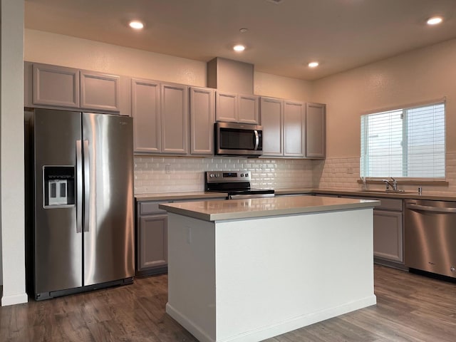 kitchen featuring dark hardwood / wood-style floors, gray cabinets, stainless steel appliances, and a center island