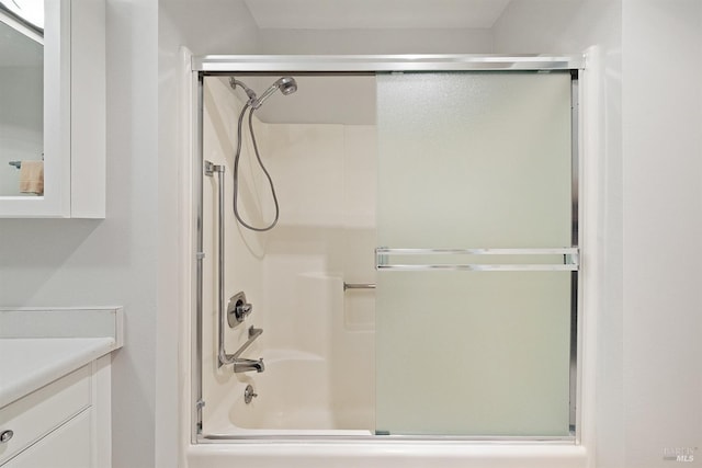 bathroom with bath / shower combo with glass door and vanity