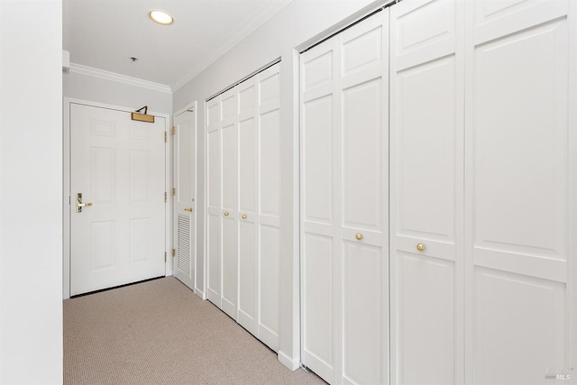 hall with ornamental molding and light carpet