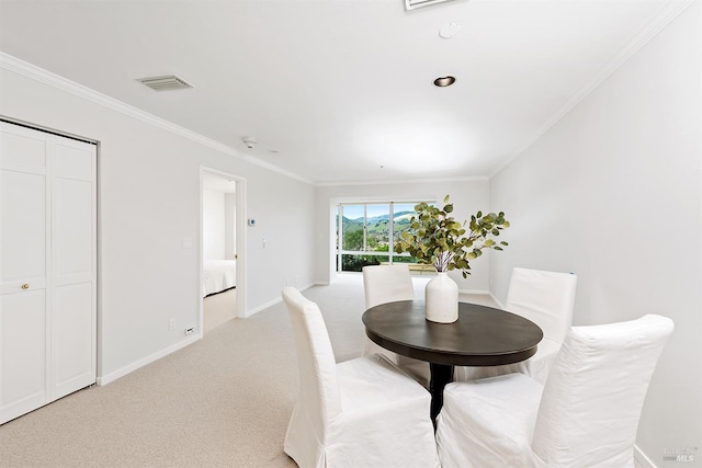 carpeted dining room featuring ornamental molding