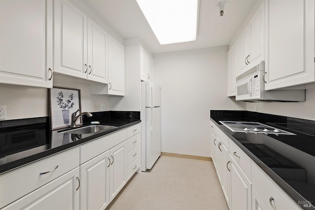 kitchen with white cabinetry, white appliances, and sink