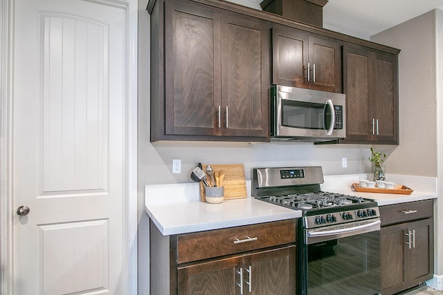 kitchen with dark brown cabinetry and appliances with stainless steel finishes