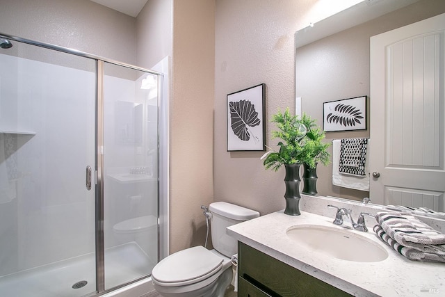 bathroom with vanity, toilet, and a shower with shower door