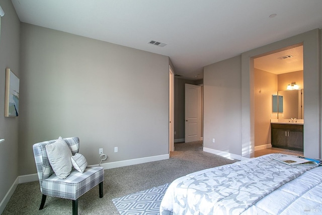 carpeted bedroom with sink and ensuite bath