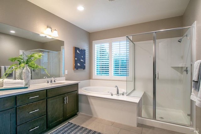 bathroom with tile patterned floors, vanity, and shower with separate bathtub