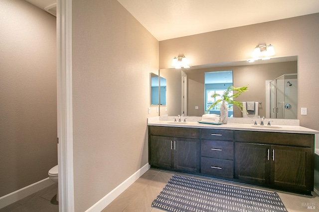 bathroom featuring tile patterned flooring, vanity, a shower with door, and toilet