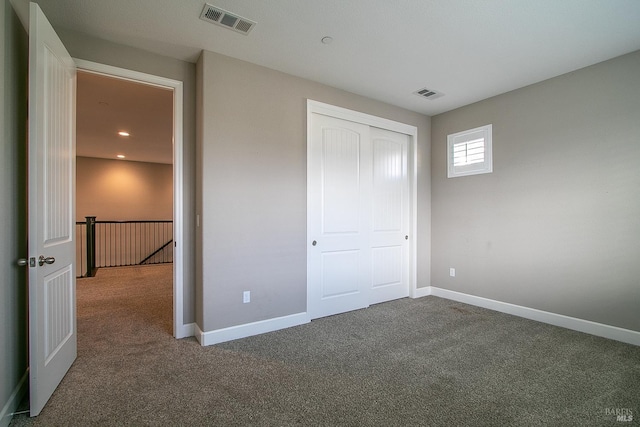 unfurnished bedroom featuring carpet floors and a closet