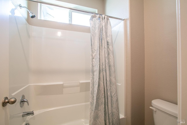 bathroom with shower / bath combo and toilet