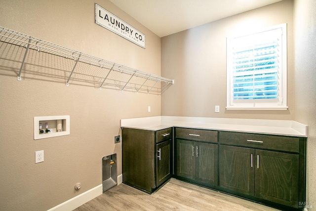 laundry area featuring hookup for an electric dryer, hookup for a washing machine, light wood-type flooring, and cabinets