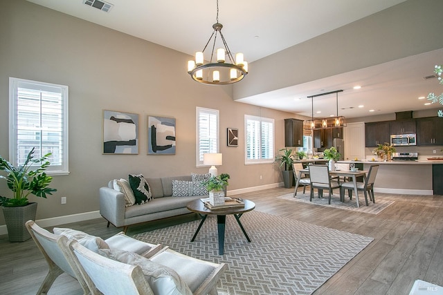 living room featuring light hardwood / wood-style floors and an inviting chandelier