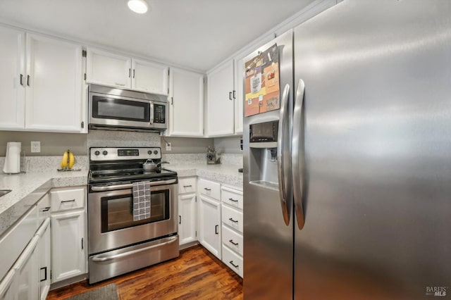 kitchen featuring dark hardwood / wood-style flooring, light stone countertops, stainless steel appliances, and white cabinets