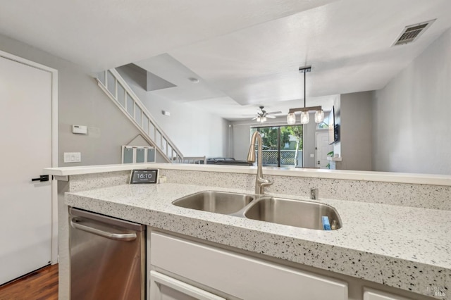 kitchen with pendant lighting, sink, dishwasher, dark hardwood / wood-style floors, and light stone counters