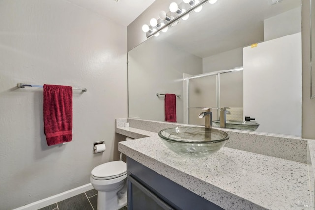 bathroom with vanity, tile patterned flooring, a shower with shower door, and toilet