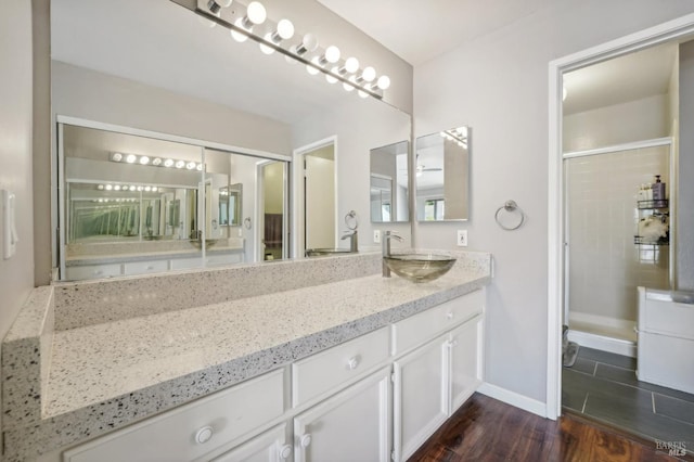 bathroom with vanity, wood-type flooring, and an enclosed shower