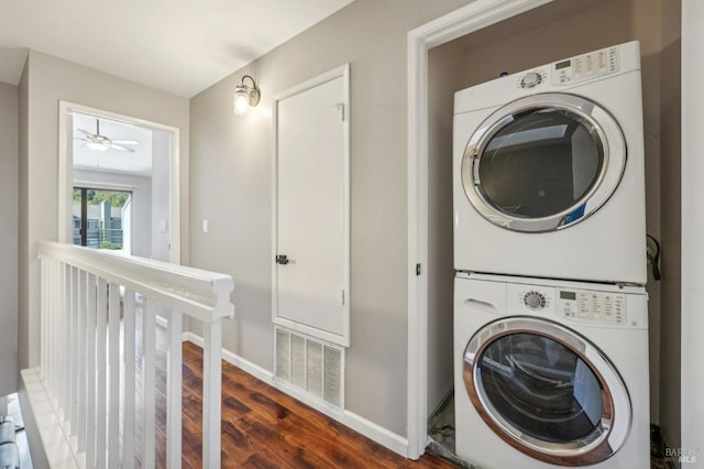 laundry room with stacked washer / drying machine and dark wood-type flooring