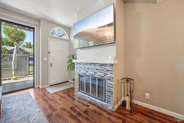 entrance foyer with a stone fireplace and dark hardwood / wood-style flooring