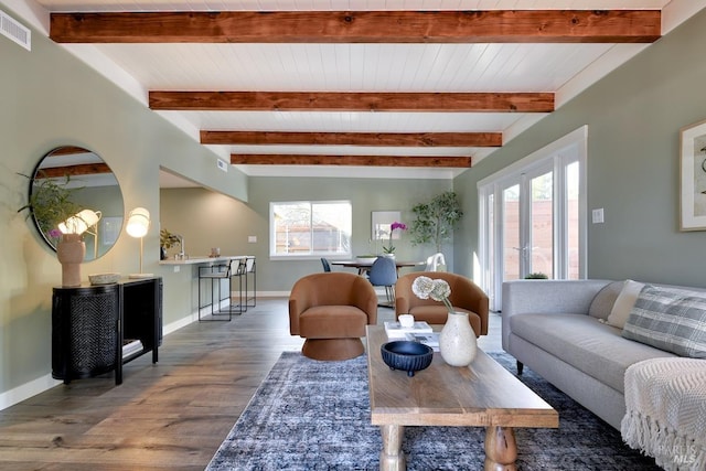 living room featuring beamed ceiling, wood finished floors, visible vents, and baseboards