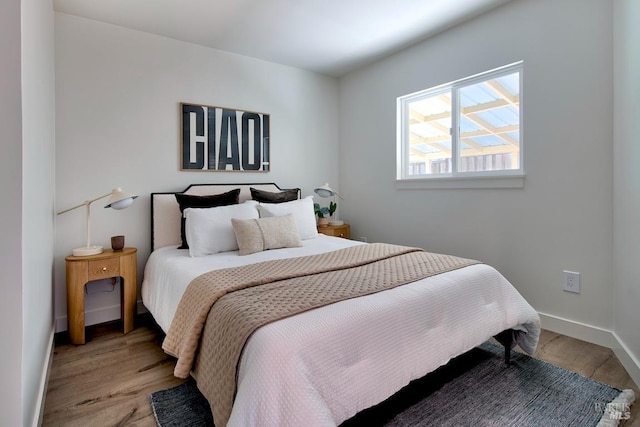 bedroom featuring baseboards and wood finished floors