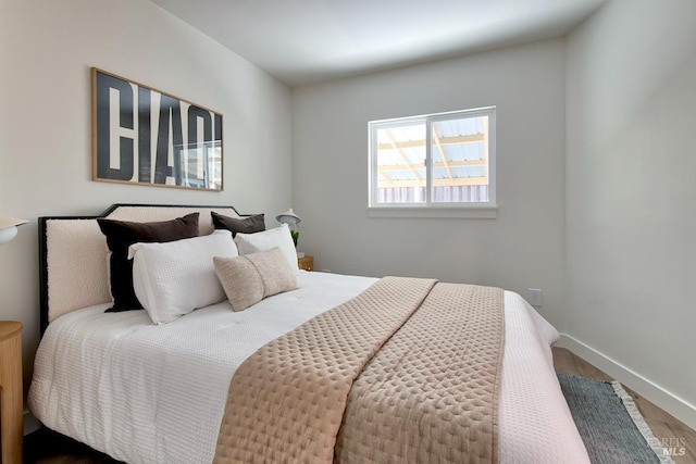 bedroom featuring baseboards and wood finished floors