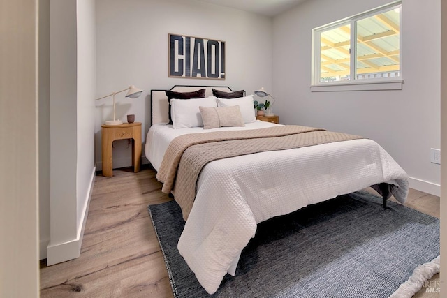 bedroom with light wood-style flooring and baseboards