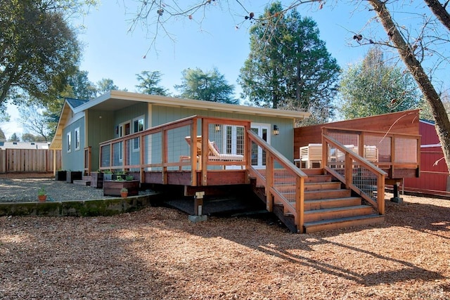 rear view of house featuring stairway, fence, and a wooden deck