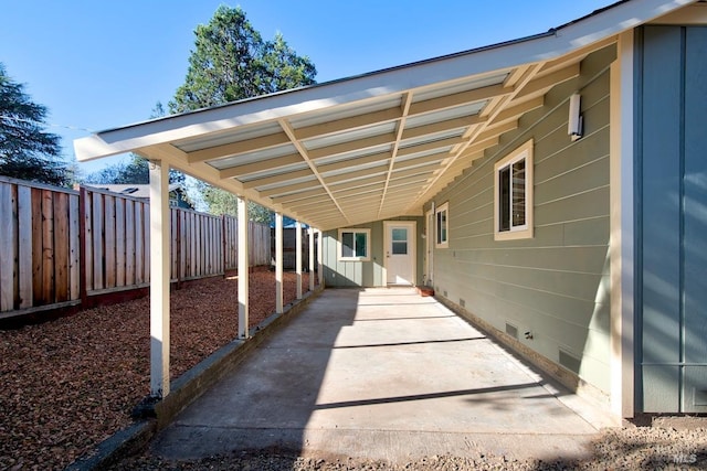 view of patio / terrace with an attached carport and fence