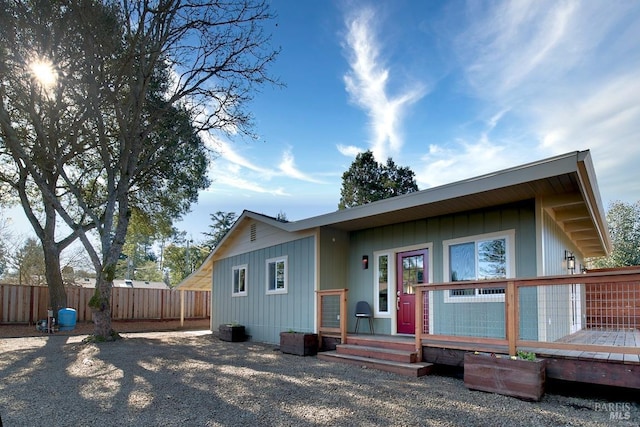 rear view of property featuring fence and a wooden deck